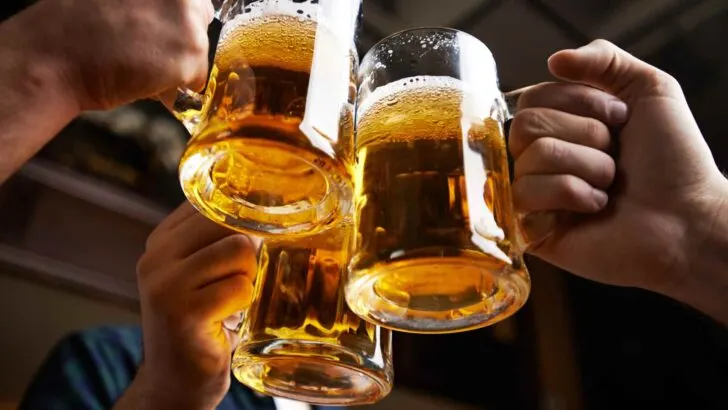 Three large beer mugs raised together