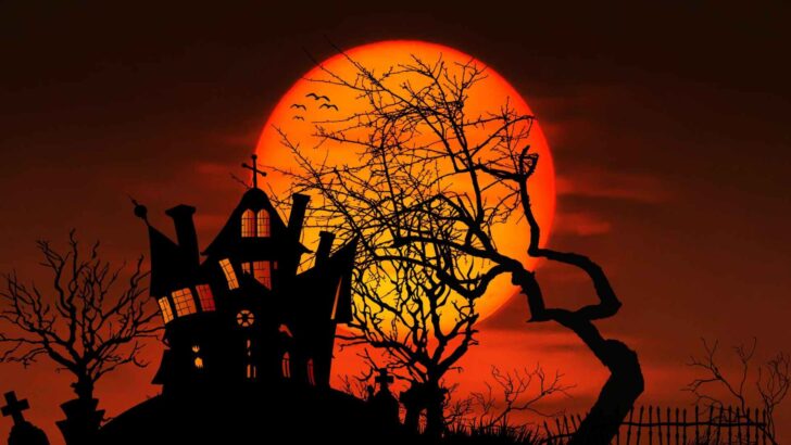 A haunted house silhouette beneath an orange full moon