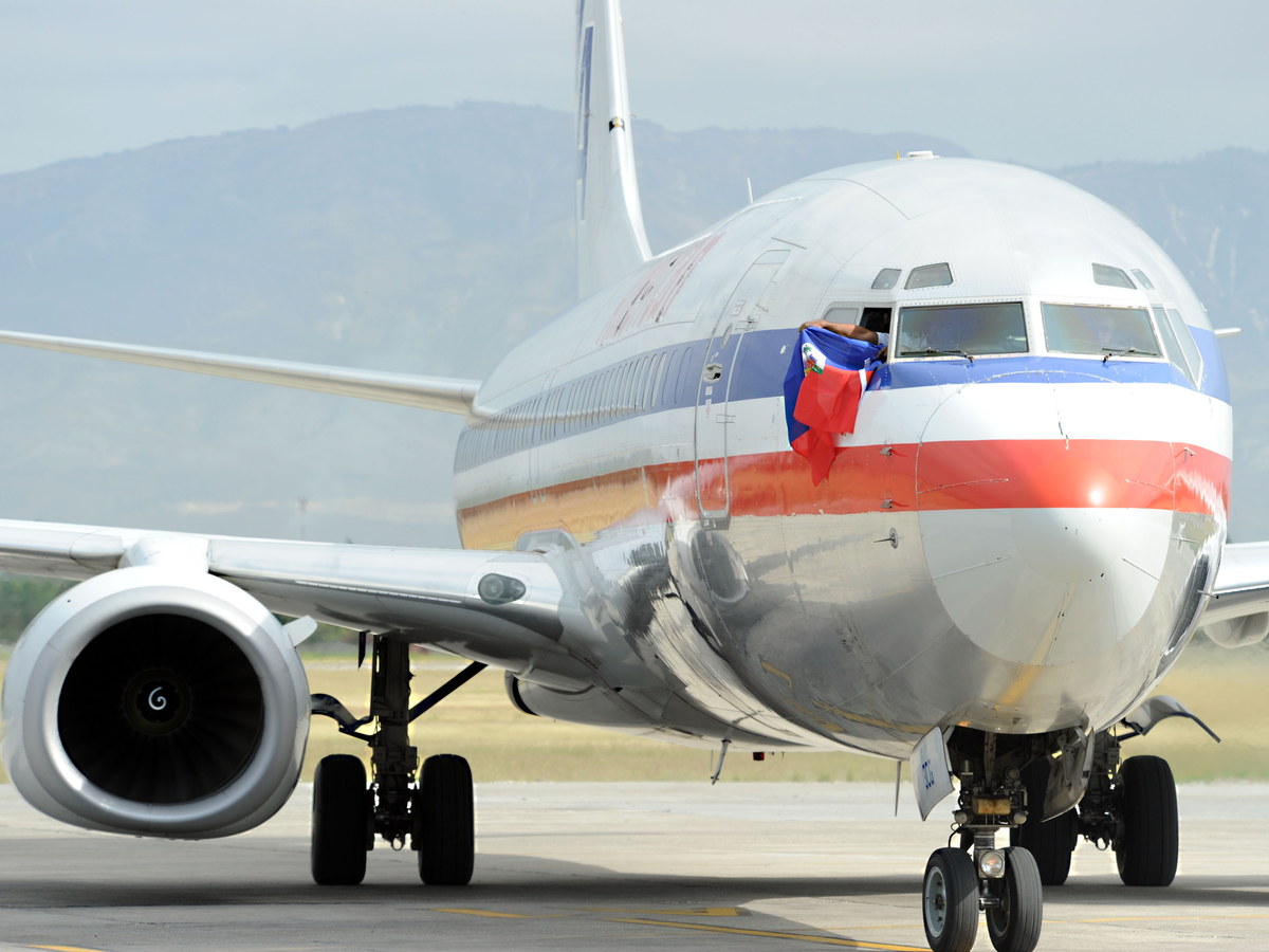 Commercial airline pilot waving a flag from the cockpit window
