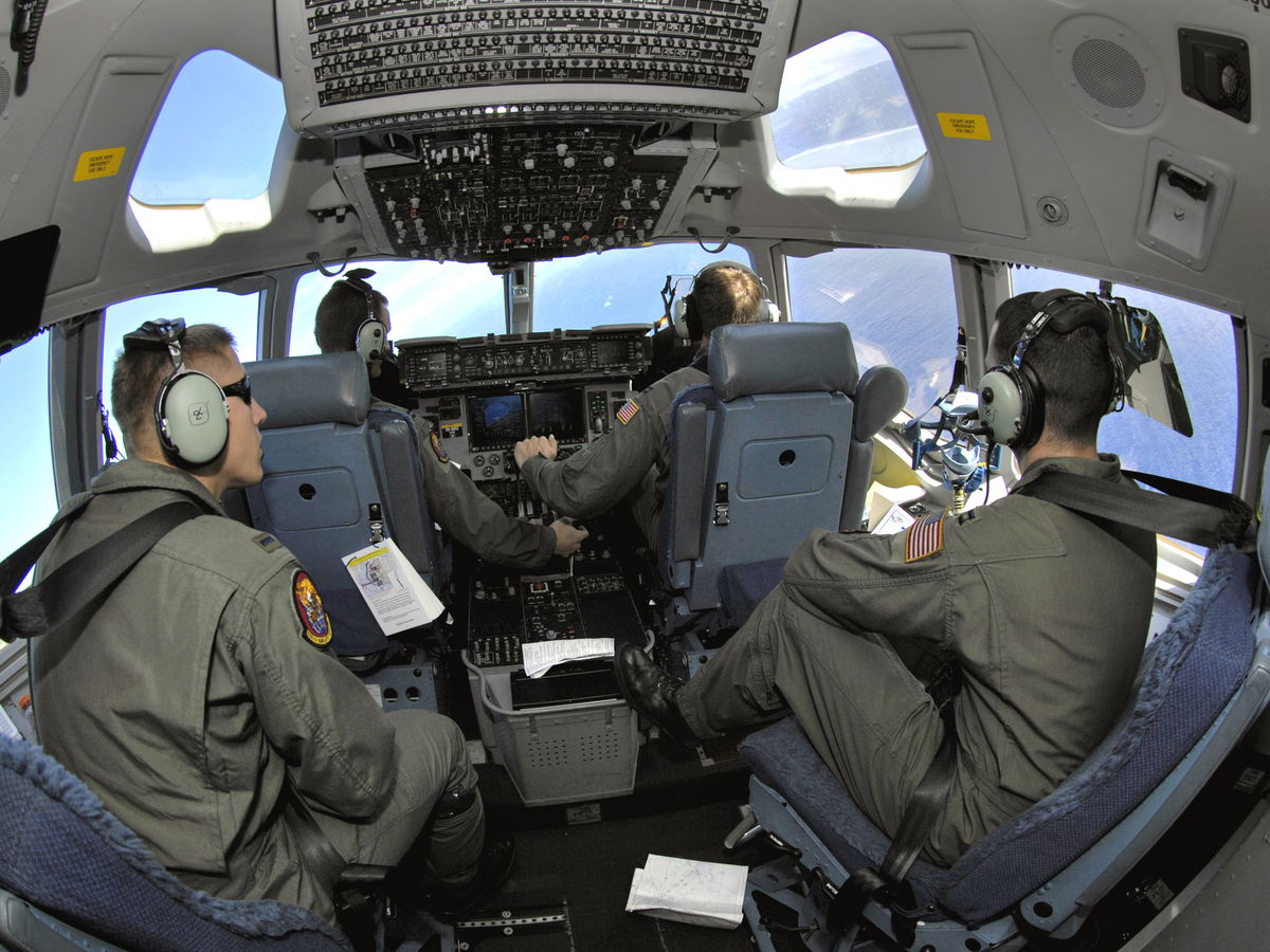 Pilots seated at the controls of a C-17 aircraft cockpit