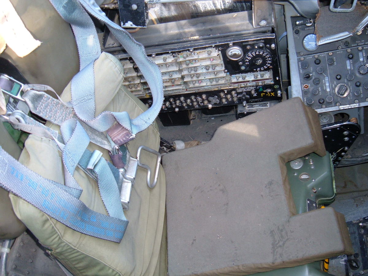 Pilot seat, harness, and controls inside an F-4 cockpit simulator