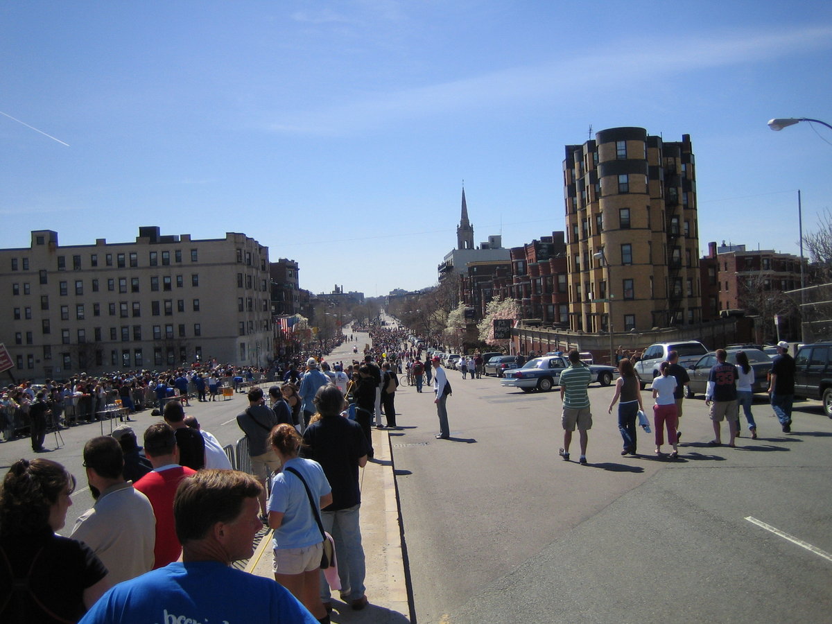 Crowds gathered along a broad city street in Boston