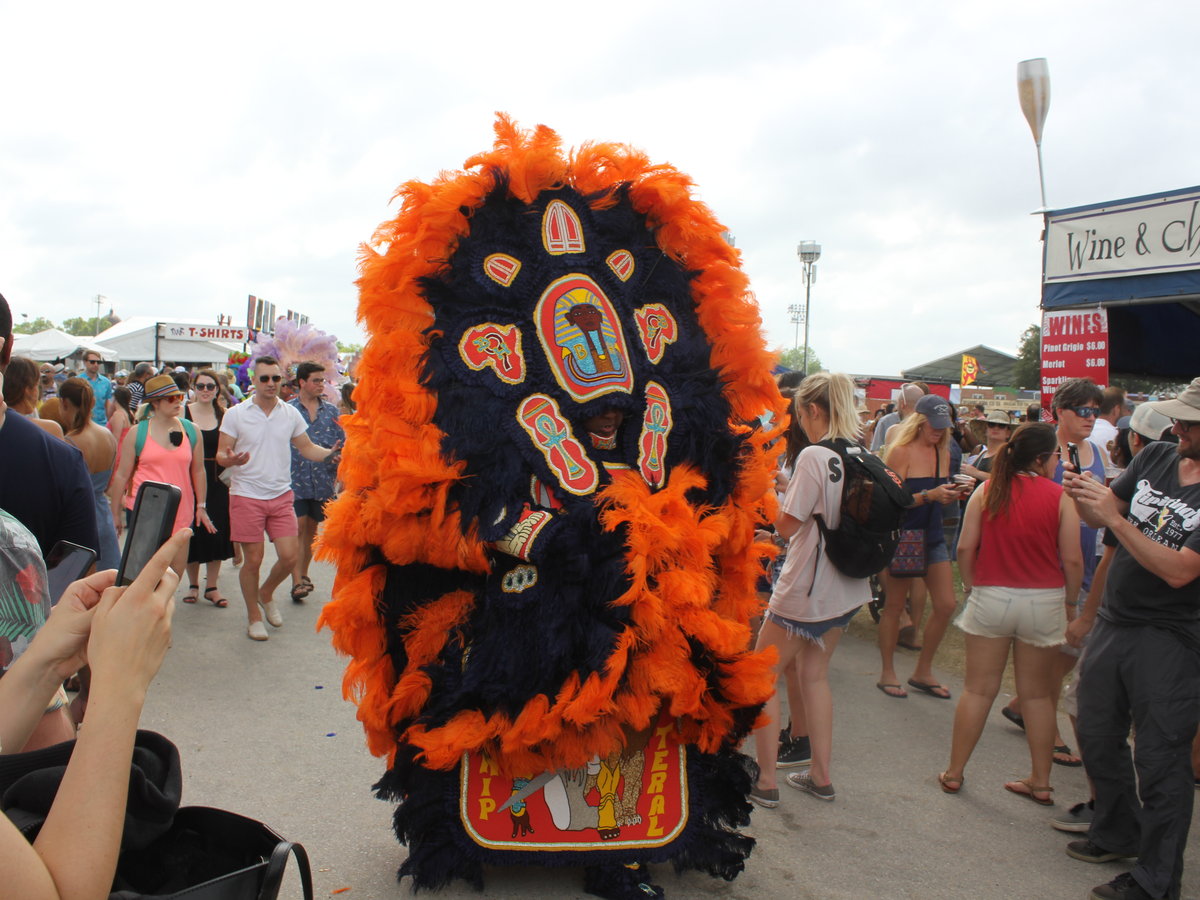 Mardi Gras Indian wearing an orange and black suit at a New Orleans celebration
