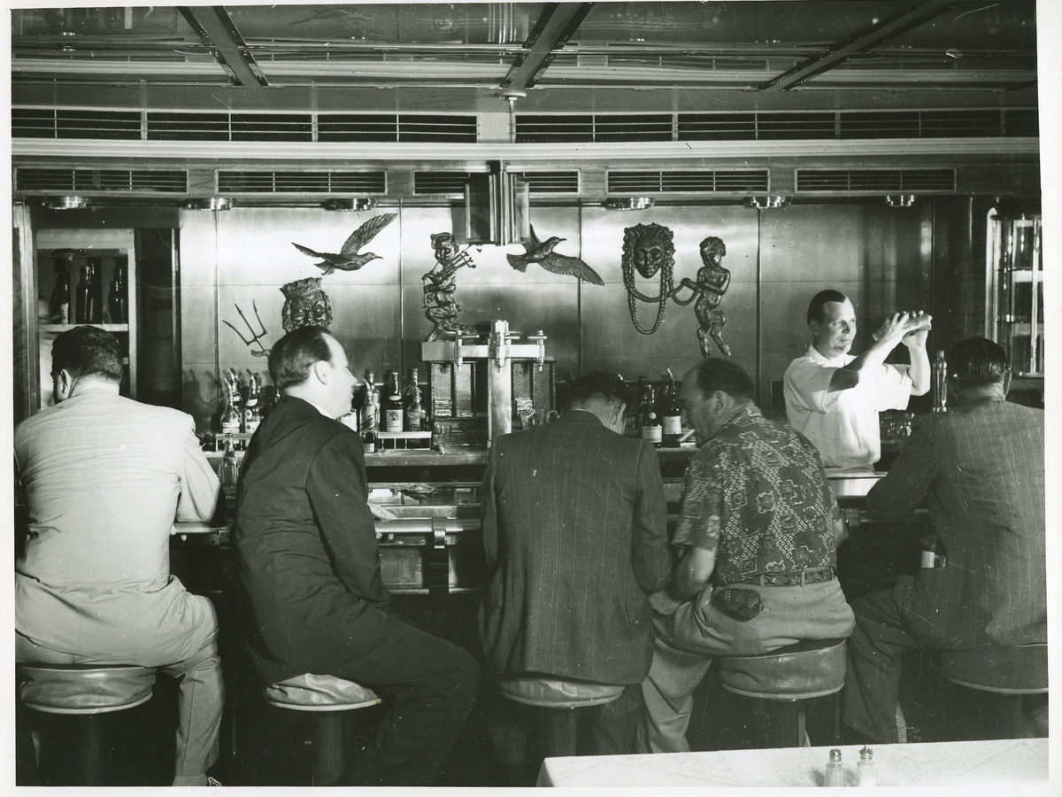 Bartender serving guests at a busy bar