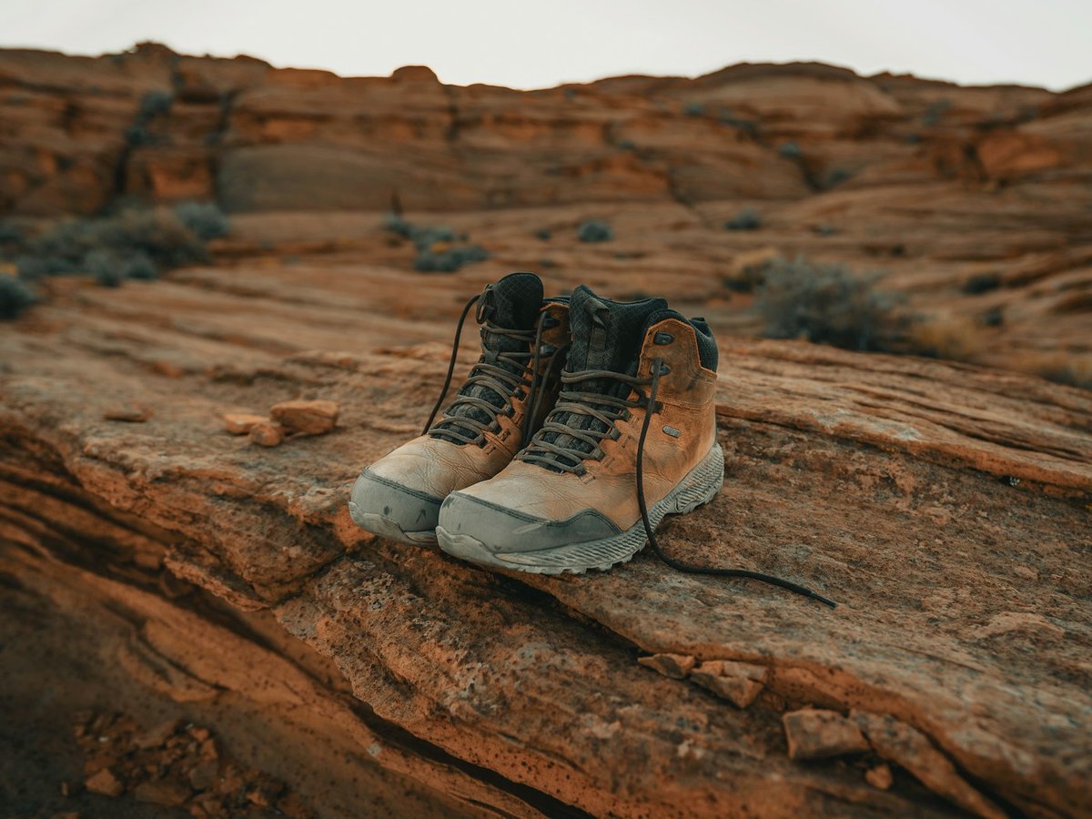 Pair of hiking boots resting on a red rock ledge