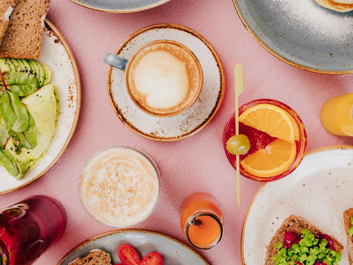 Overhead view of a colorful brunch spread with coffee and fruit