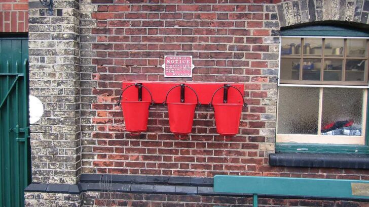 Three red metal fire buckets ready for safe cleanup