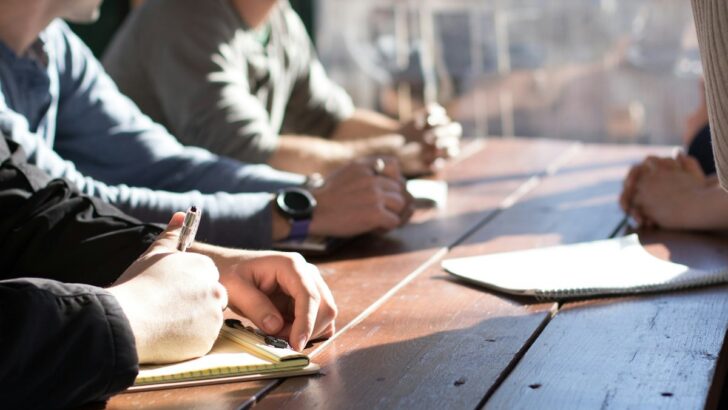 Business professionals taking notes during a meeting