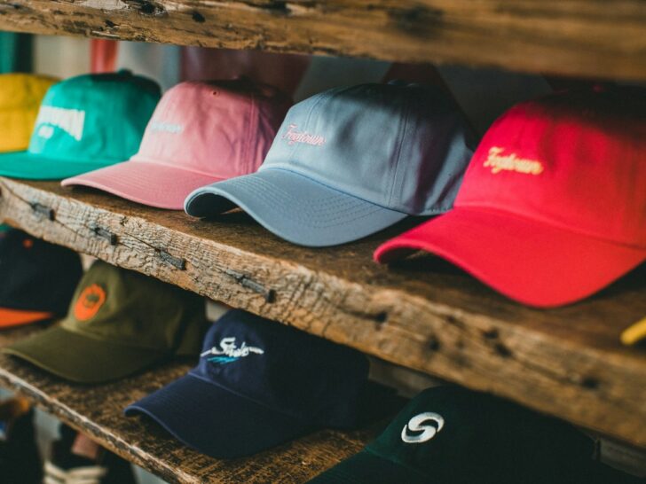 Row of colorful baseball caps displayed on a wooden shelf
