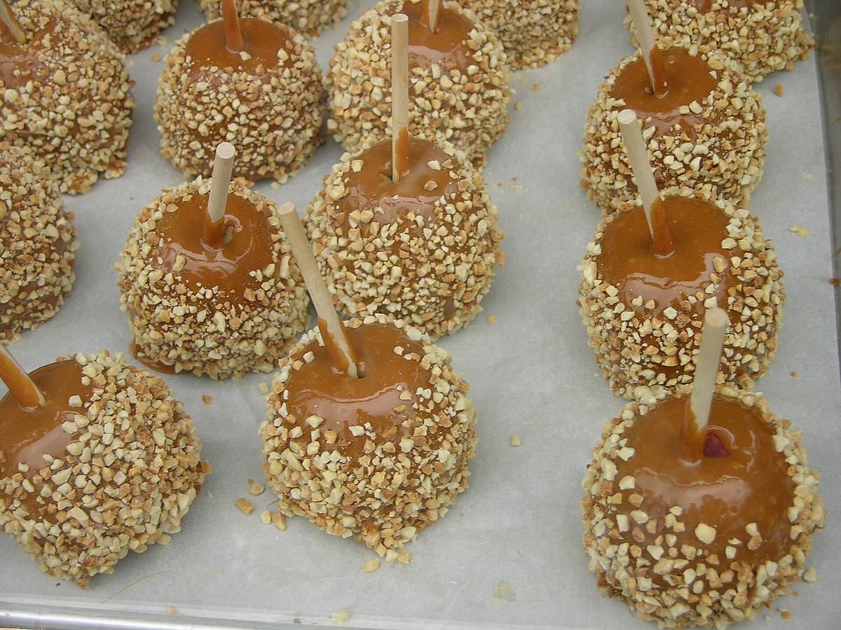 Caramel-coated apples covered with chopped peanuts