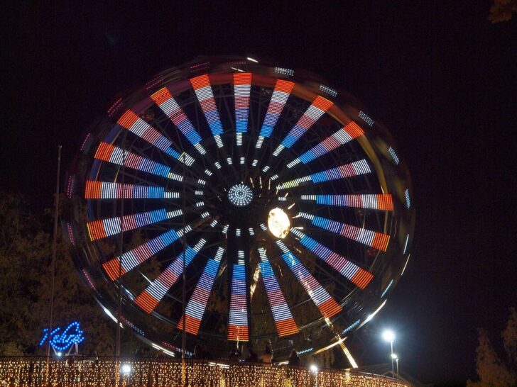 Illuminated amusement ride glowing at a nighttime carnival