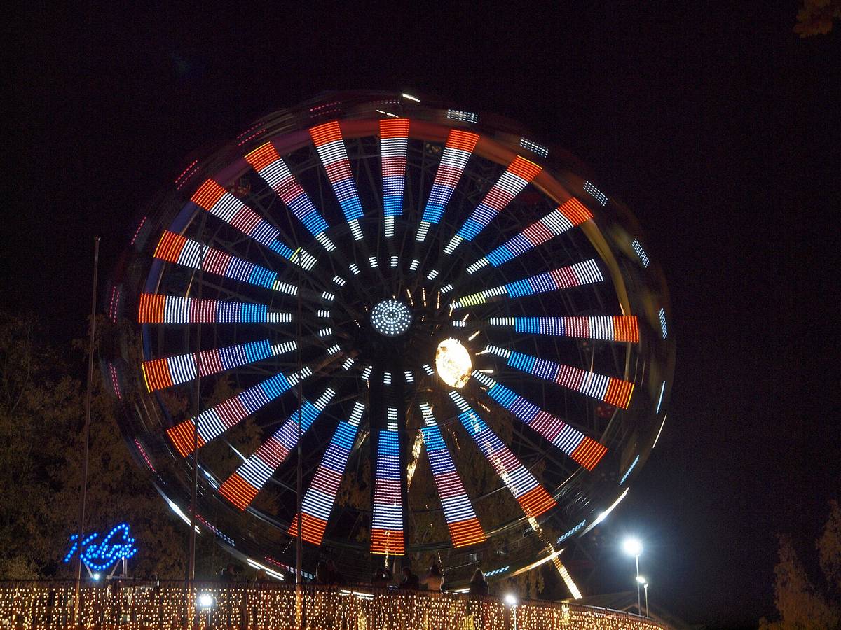 Illuminated amusement ride glowing at a nighttime carnival