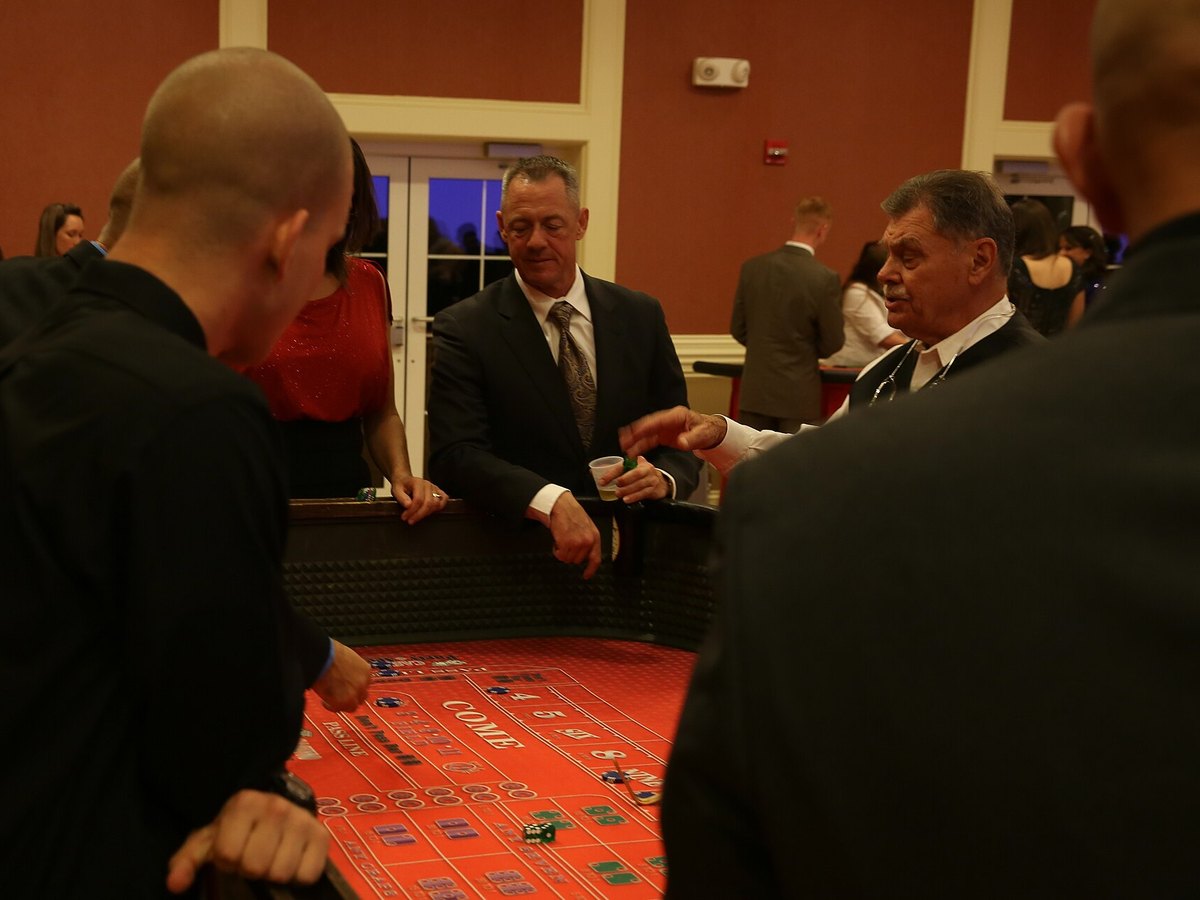 Guests playing a casino table game at an evening event