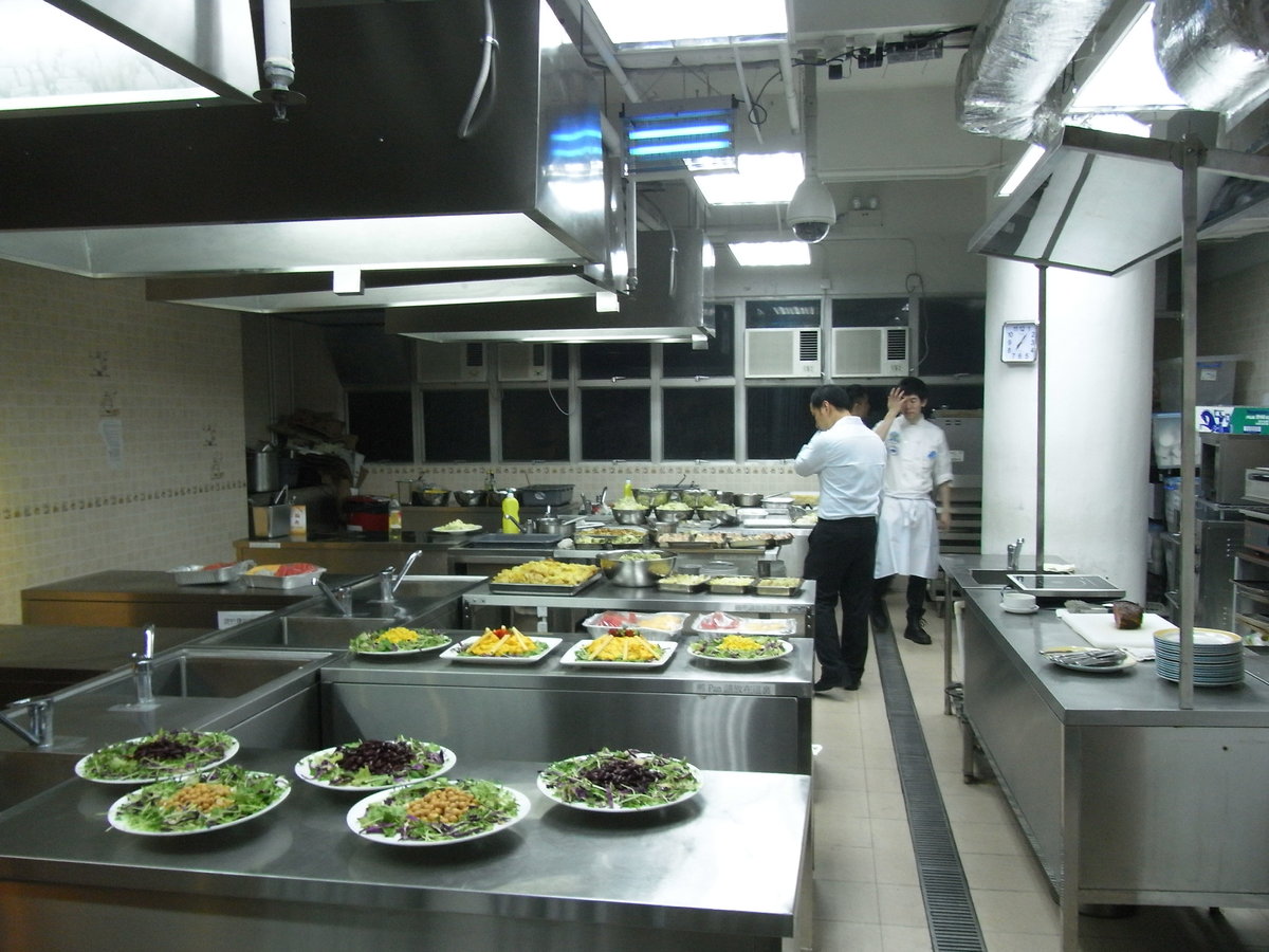 Chefs preparing plated dishes in a professional kitchen