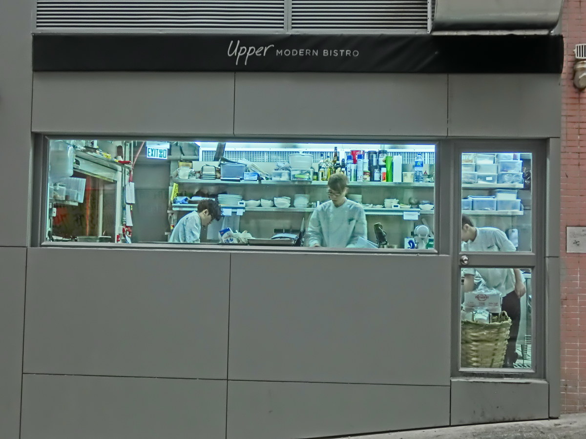 Chefs working inside a busy restaurant kitchen