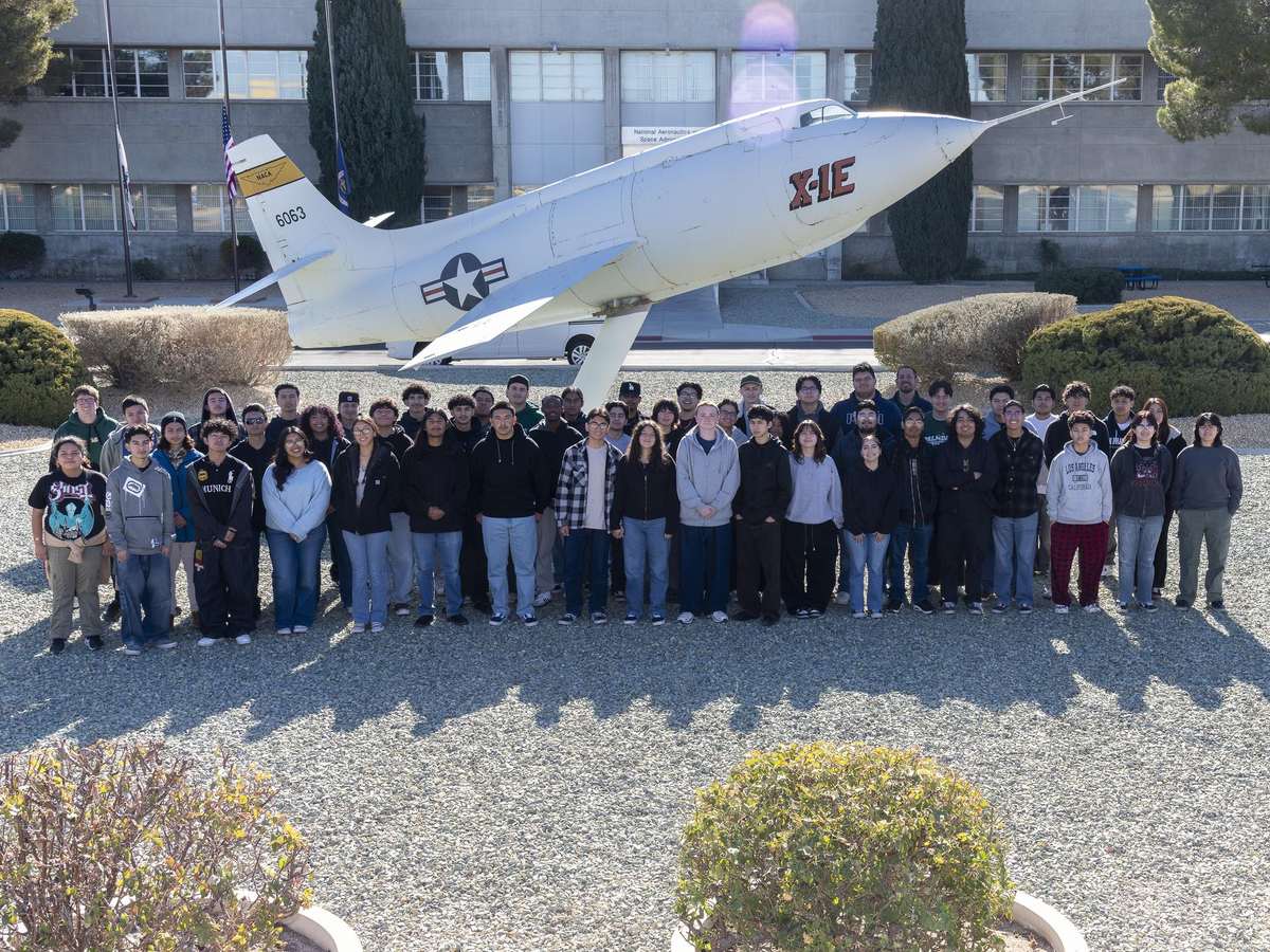 Engineering students and a NASA mentor working on a technical project