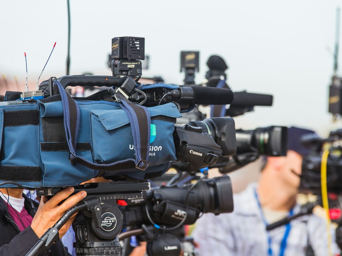 Television journalists and camera crews covering an event