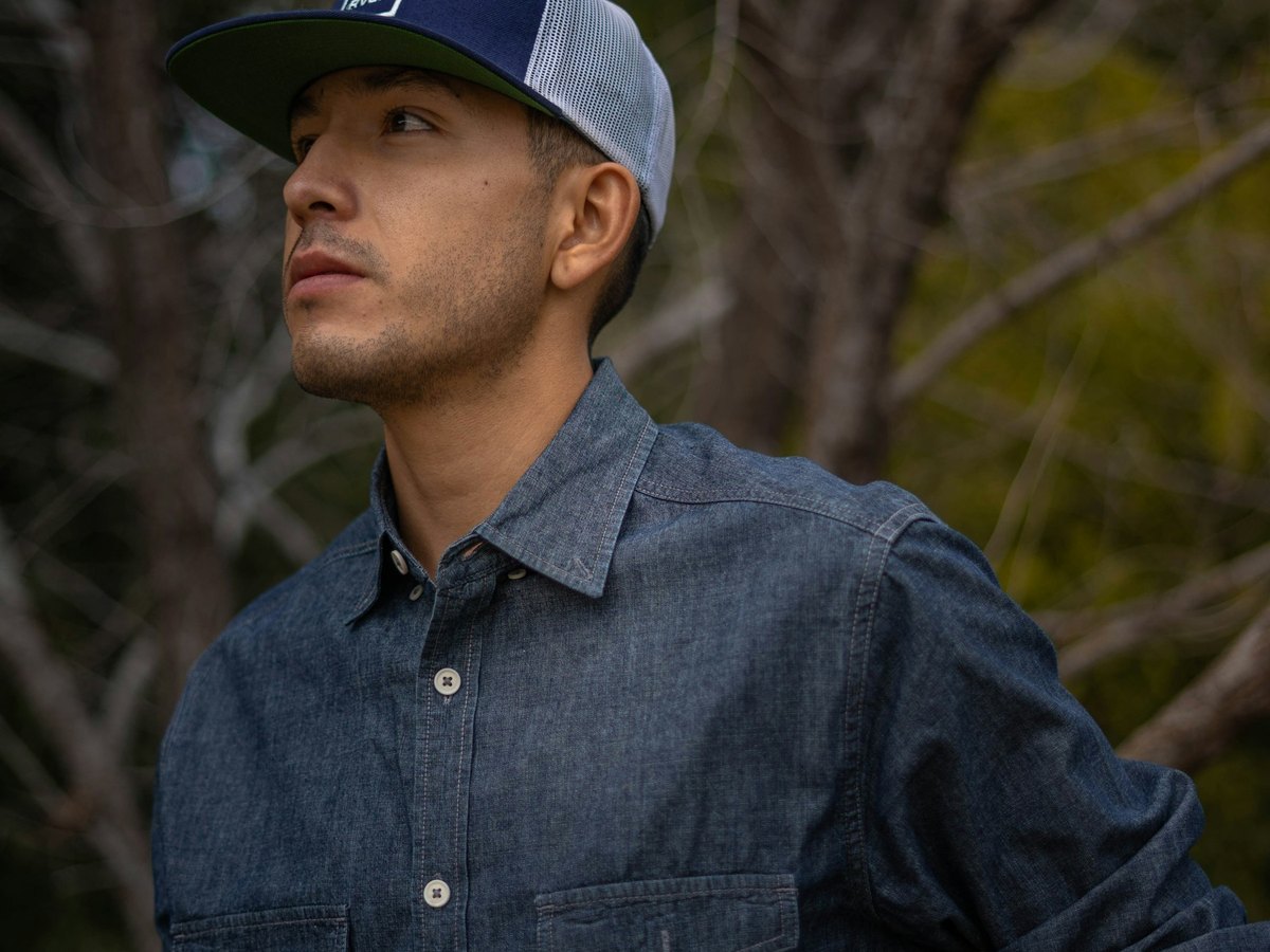 Man wearing a blue fitted baseball cap outdoors