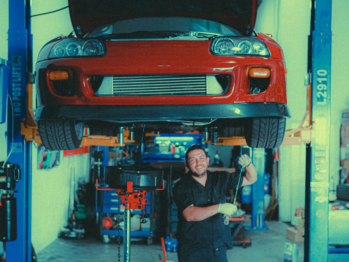 Professional mechanic repairing a red car in a garage
