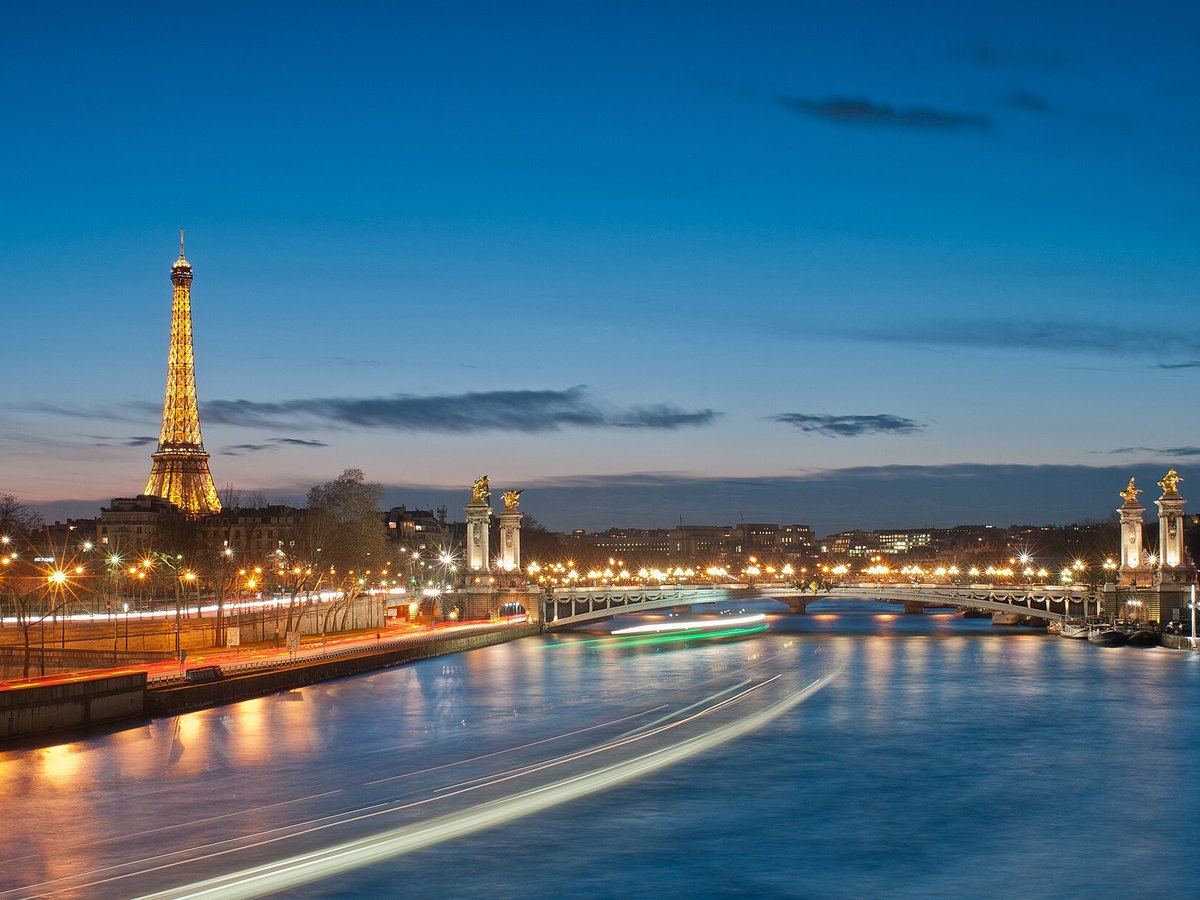 Eiffel Tower and Pont Alexandre III illuminated at night in Paris