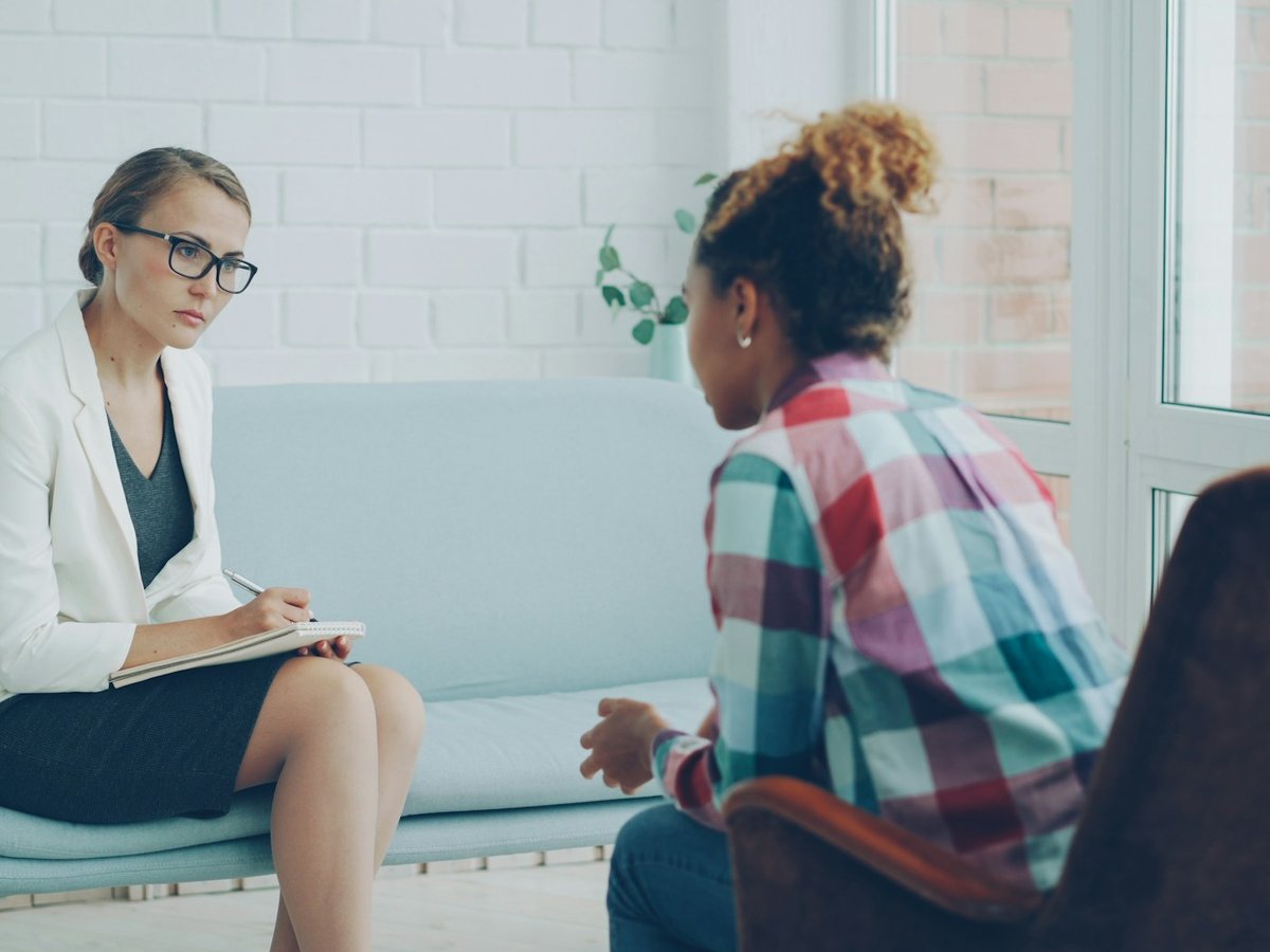 Psychologist taking notes while a client speaks