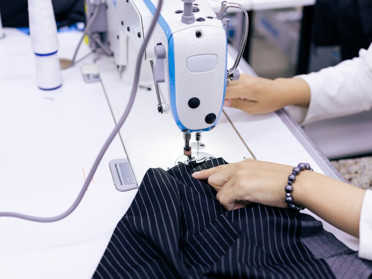 Tailor sewing a striped garment on an industrial machine