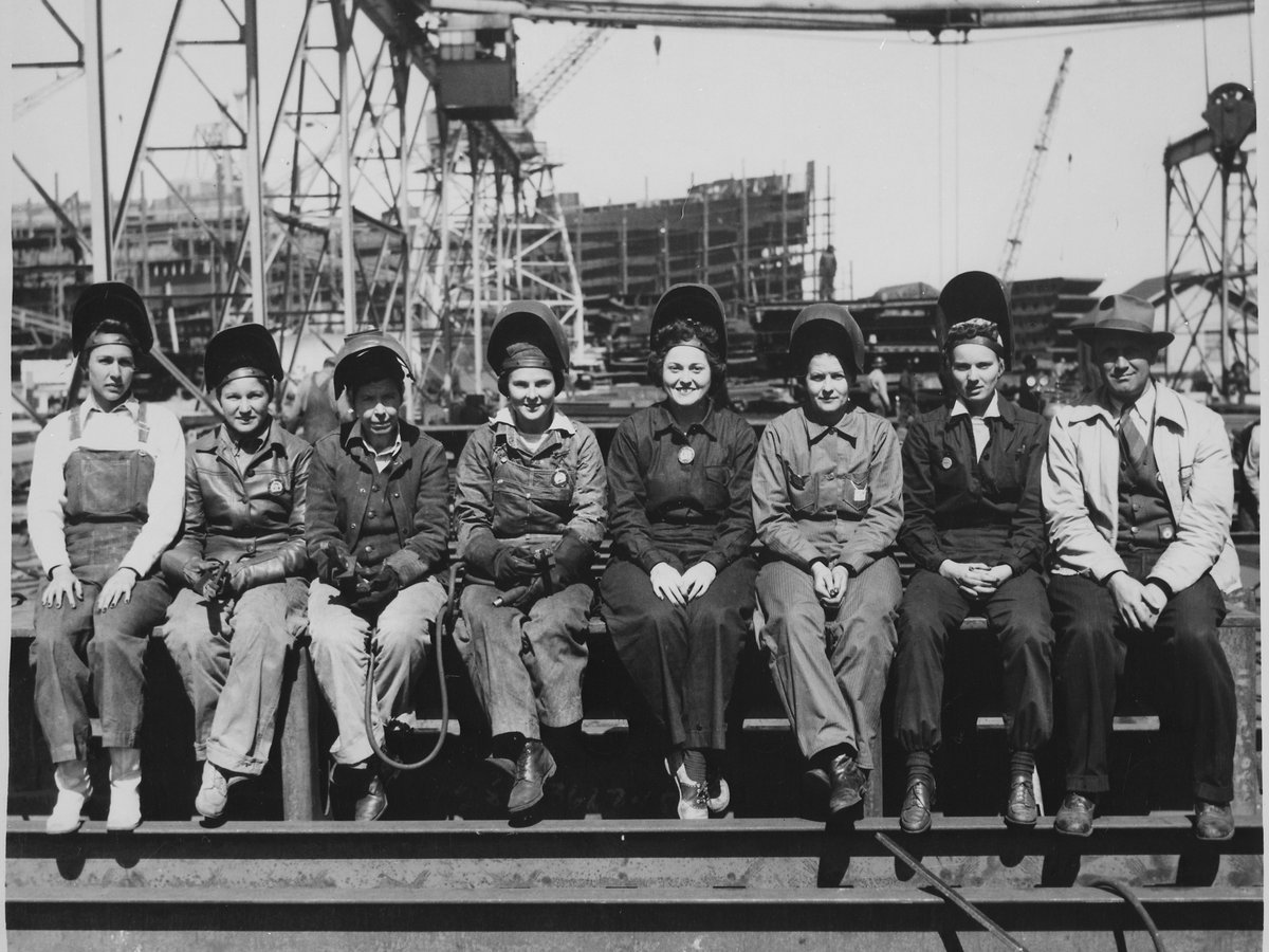 Group of welders and shipyard workers seated together